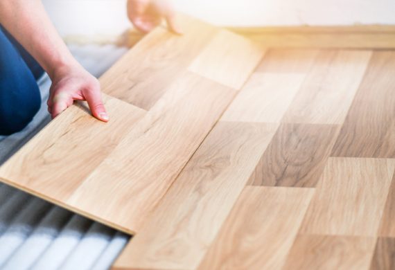 A person laying laminate flooring