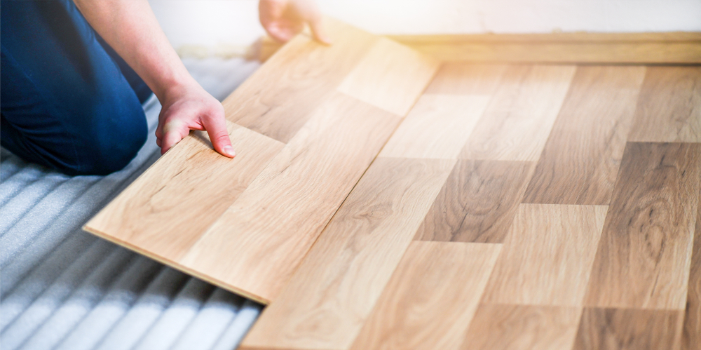 A person laying laminate flooring