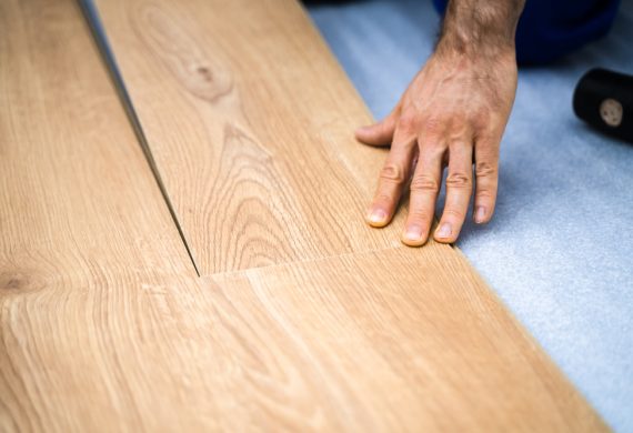 A worker laying wooden flooring