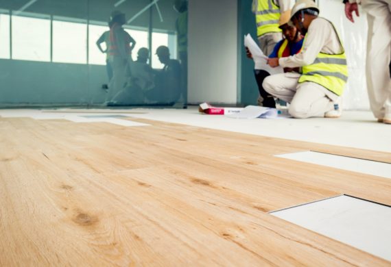 Builders laying down a laminate floor