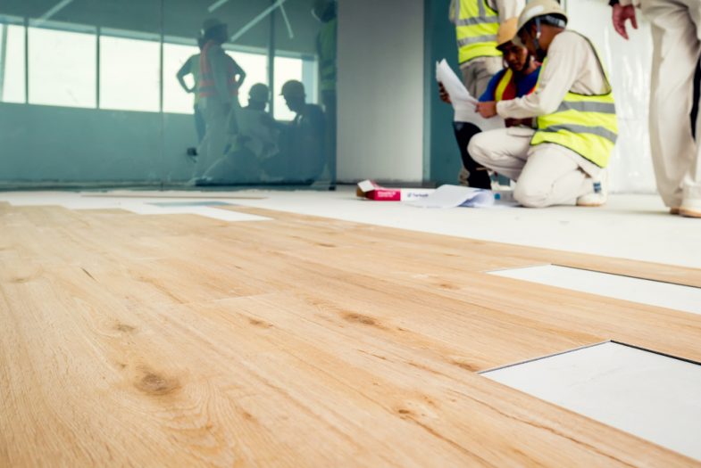 Builders laying down a laminate floor